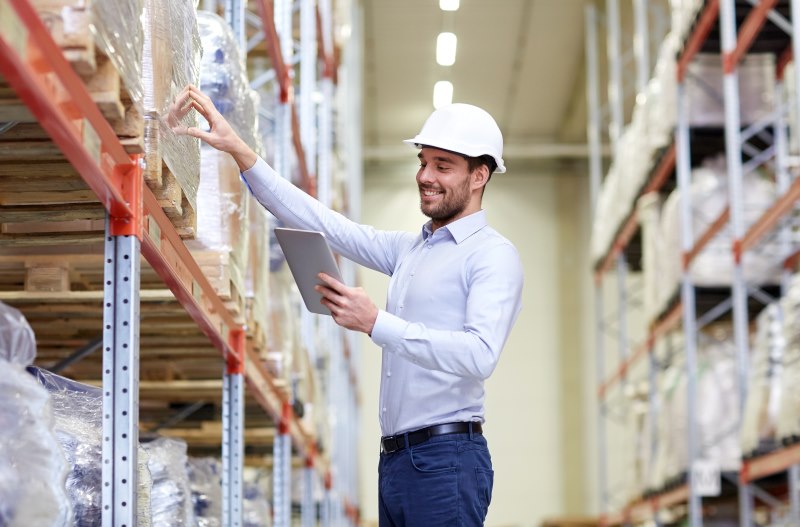 Employee checks stock levels with warehouse management system via app