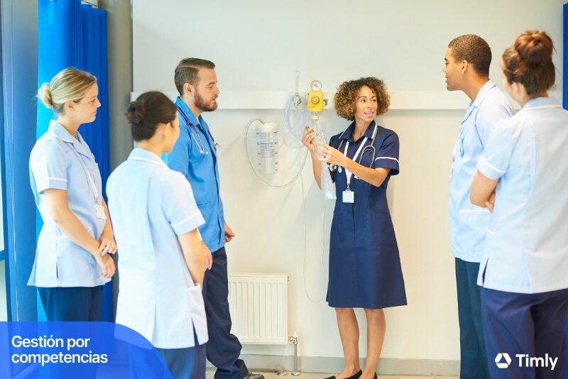 Un grupo de profesionales médicos en capacitación, liderados por una instructora. La imagen destaca la gestión por competencias en el entorno de salud.