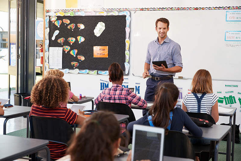 Teachers using school management software to organize class schedules and manage student records