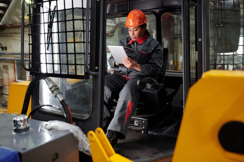 Employee using a smartphone to scan a QR code on a company vehicle for fleet management