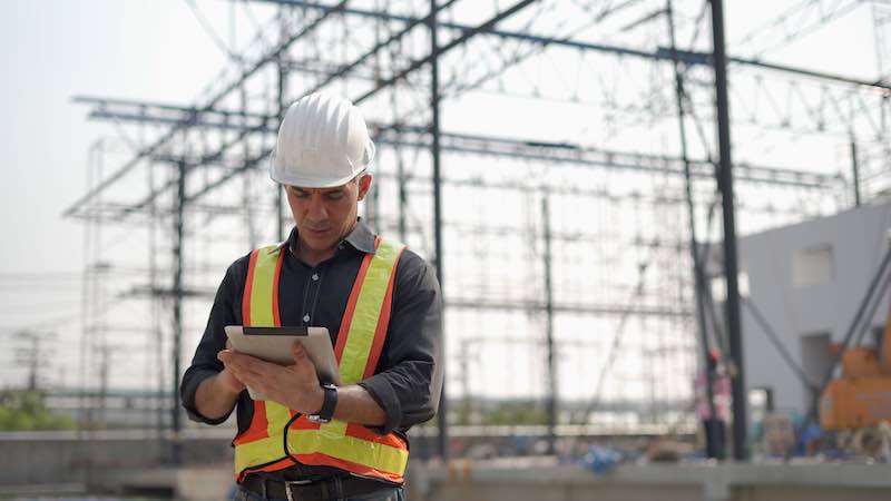 Worker scanning a QR code on a ladder to access inspection details as per the Work at Height Regulations 2005