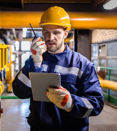 Firma digital en la industria Trabajador industrial utilizando una tablet para gestionar procesos y firmar digitalmente en la planta.