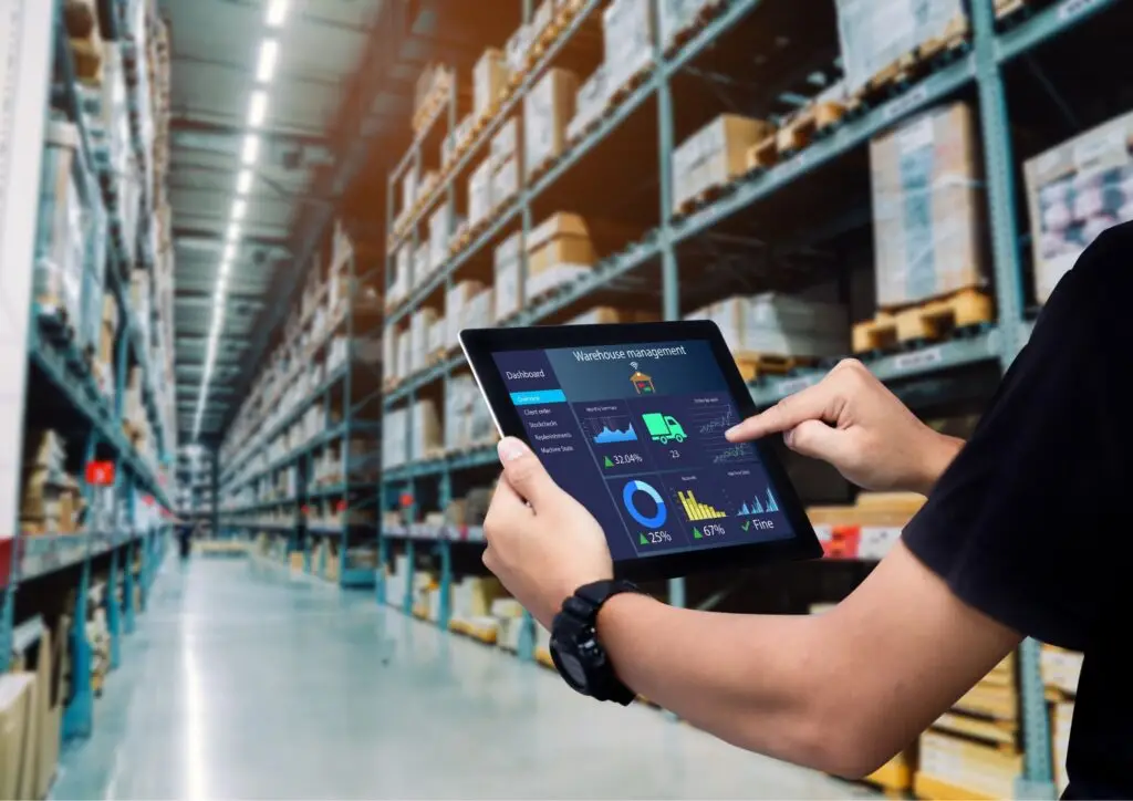 Gestión de inventarios en almacén con sistema ERP en tableta, mostrando dashboard de stock y logística en tiempo real
