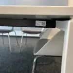 Etiqueta con código QR debajo de una mesa en la IHK Hannover como parte del sistema de inventario digital de Timly.