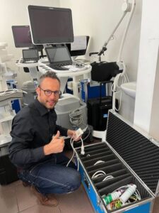 Empleado de Philips preparando equipos médicos de demostración en un entorno clínico, junto a una caja de componentes.