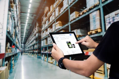 Un employé utilise le logiciel de gestion des stocks Timly dans un entrepôt, sur une tablette