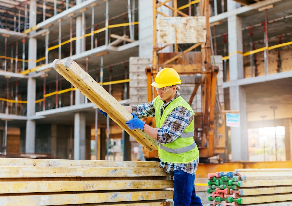 L'image représente un ouvrier sur un chantier de construction, terrain sur lequel les commandes internes de matériel sont essentielles