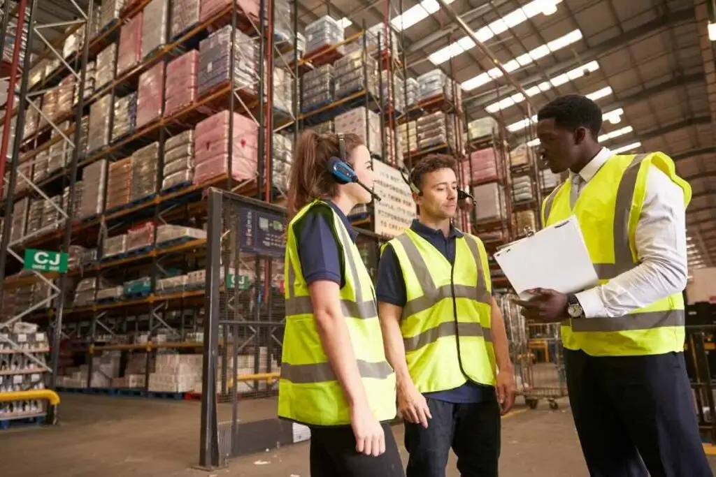 Des employés dans un immense entrepôts discutent entre eux pour illustrer un article sur la méthode ABC dans le contexte de la gestion des stocks