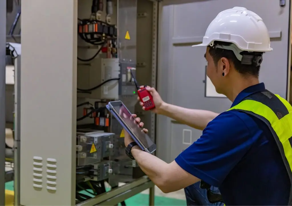 Técnico realizando mantenimiento predictivo con cámara termográfica en un cuadro eléctrico