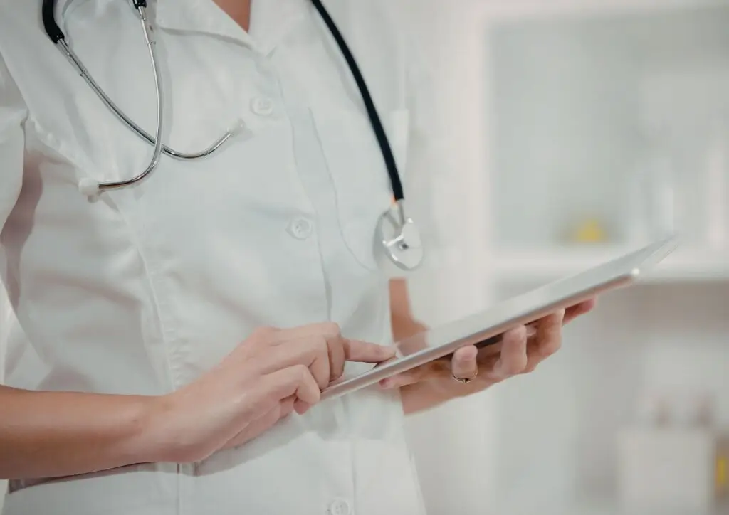 Profesional sanitario revisando información digital durante la vigilancia de la salud de los trabajadores